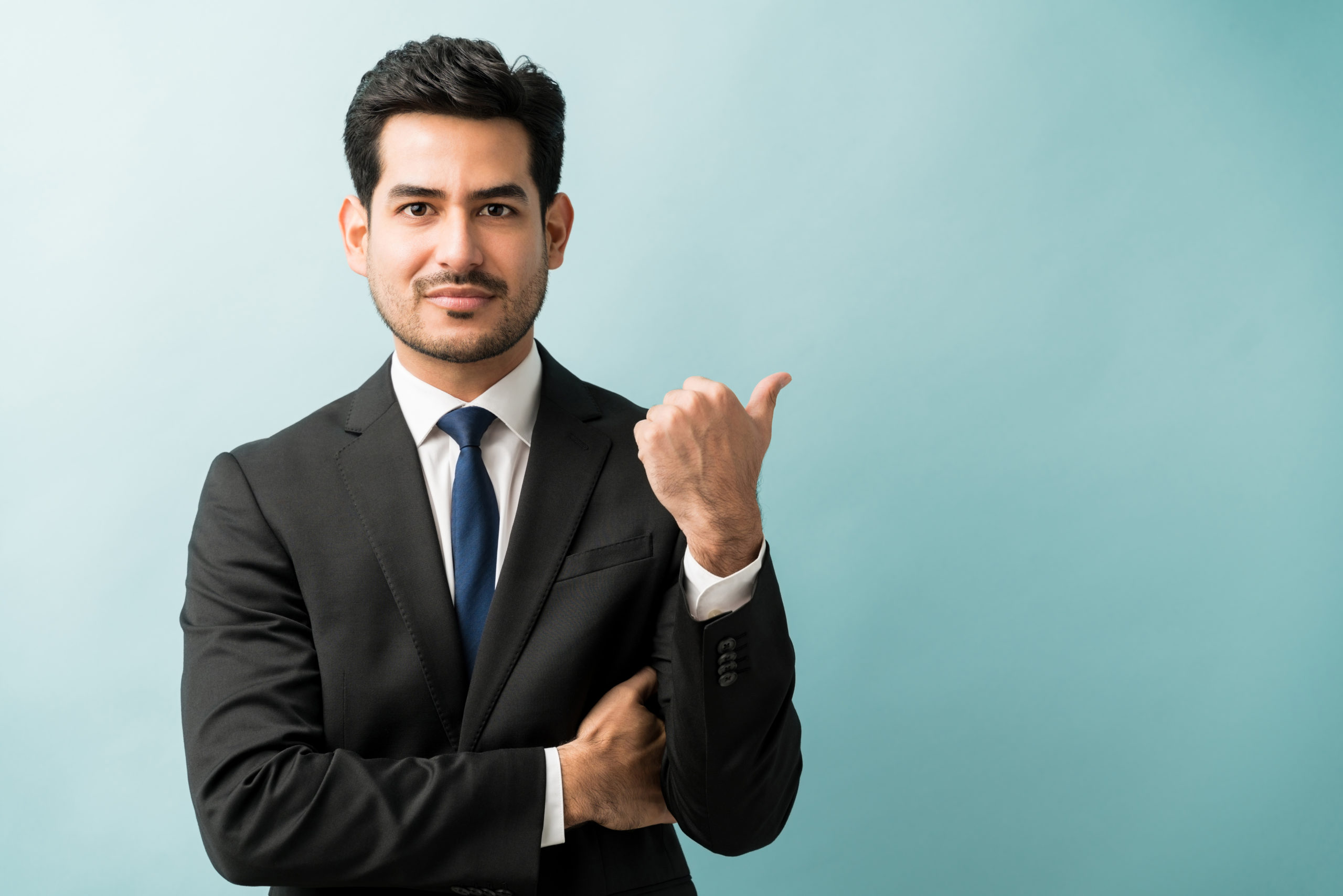 portrait-of-businessman-pointing-with-thumb-at-studio